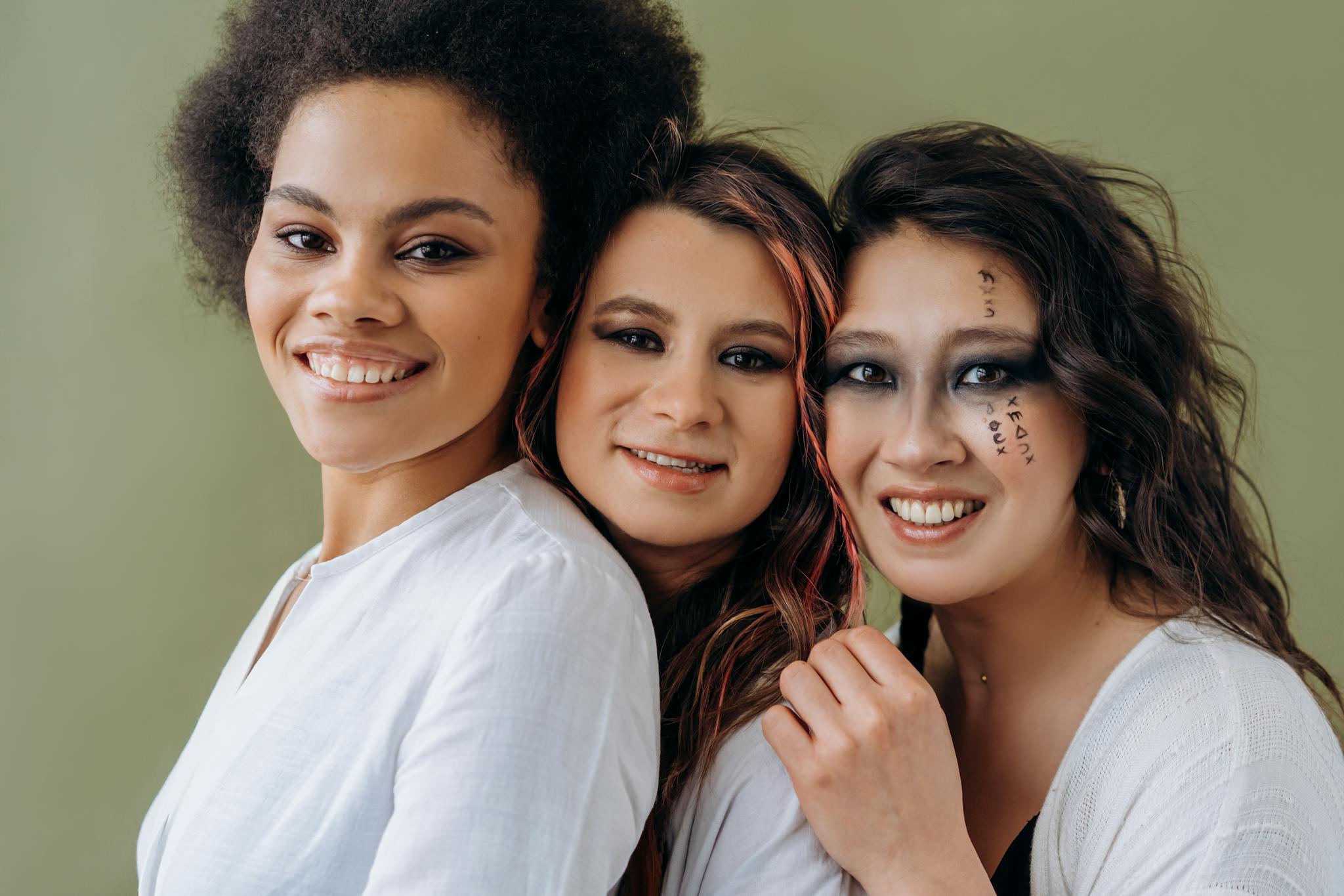 Three women sharing a joyful moment, showcasing diversity and friendship.